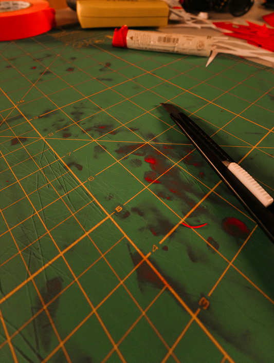 cutting mat with craft knife and glue — handmade latex clothing made in Canada